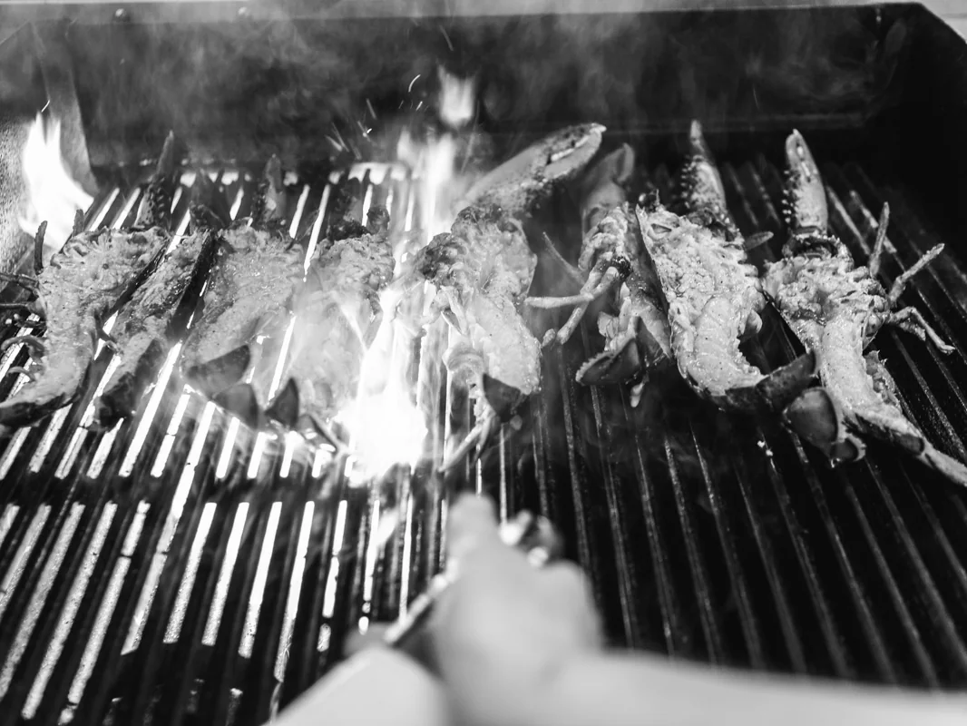 Havskräftor på den öppna grillen, med höga lågor